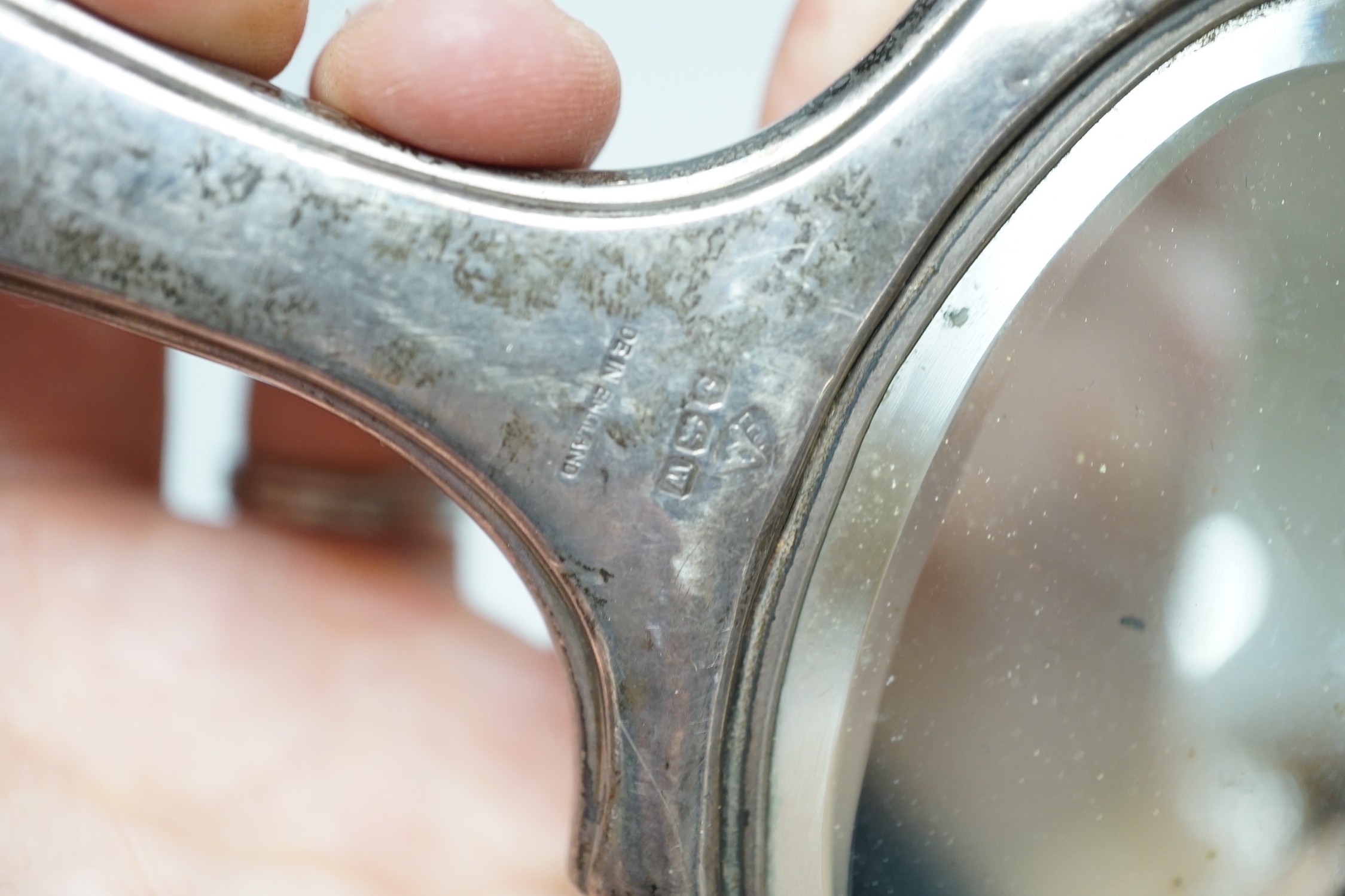 A set of six modern silver napkin rings, a George V silver sauceboat and a silver mounted hand mirror.